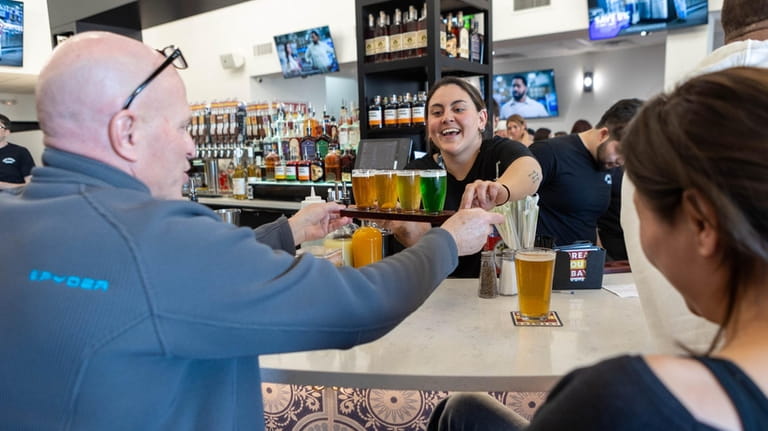 Bartender Jessica O’Keeffe delivers a beer flight at The Great South...