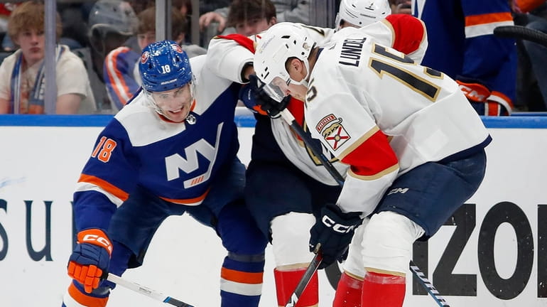 Pierre Engvall of the Islanders and Anton Lundell of the Panthers battle...