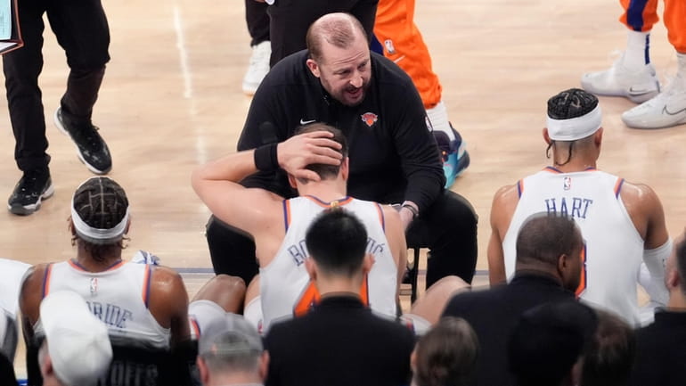 Knicks head coach Tom Thibodeau, center, gives his team instruction...