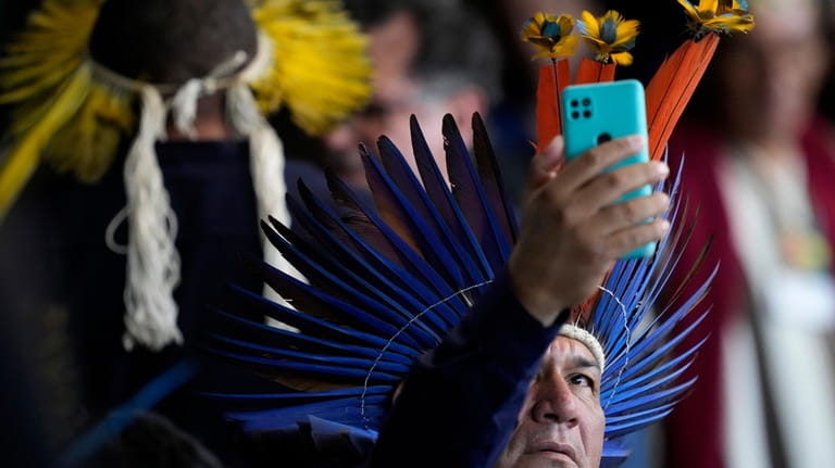 An Indigenous representative takes a photo with his cell phone...