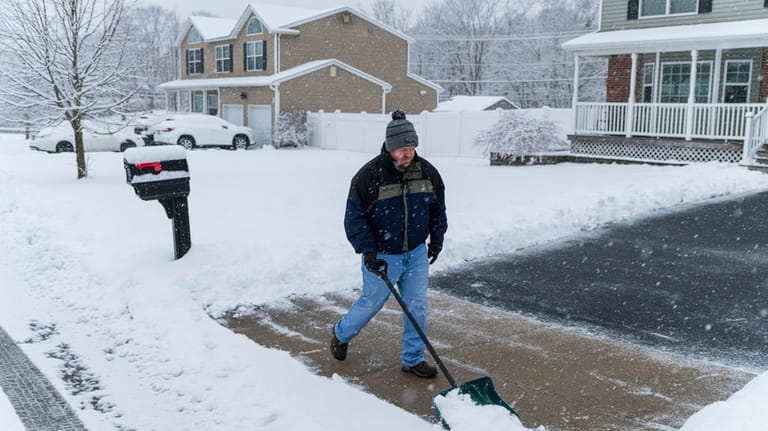 Gary Stack, 40, shovels snow from his driveway in Yaphank on...