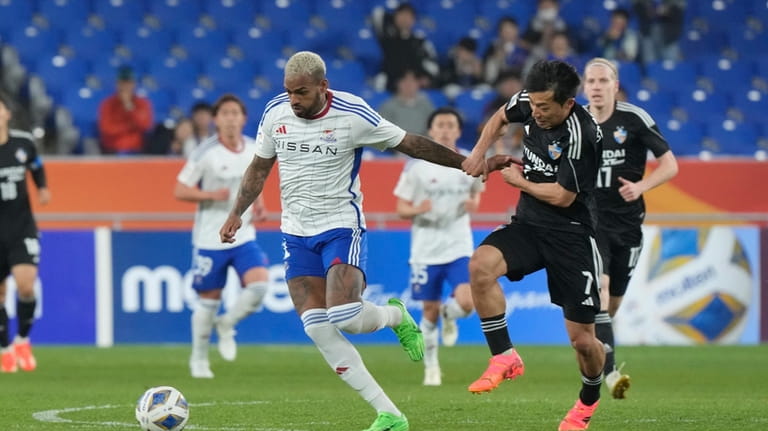 Yokohama F. Marinos' Anderson Lopes, left, is blocked by Ulsan...