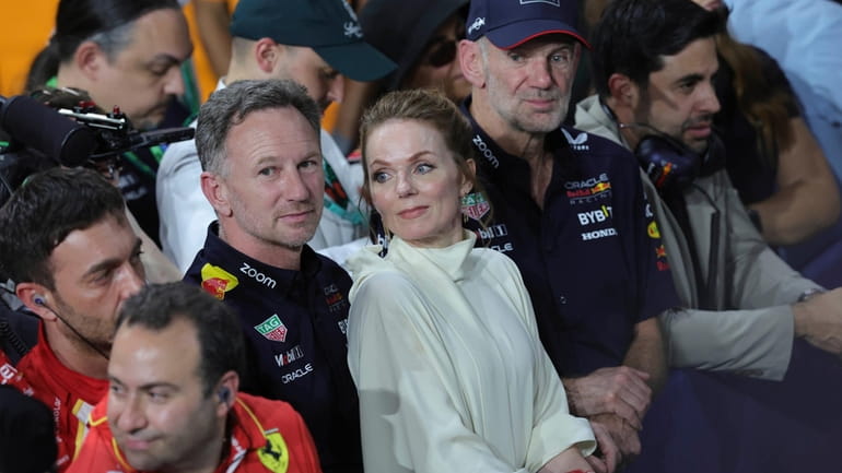 Red Bull team principal Christian Horner is flanked by his...
