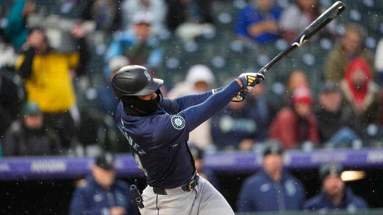 Seattle Mariners' Julio Rodríguez follows through with his swing after...