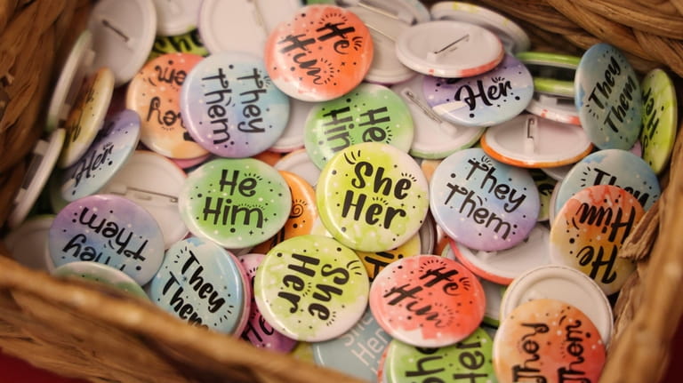 Buttons display pronouns used by many in the LGBTQ+ community...