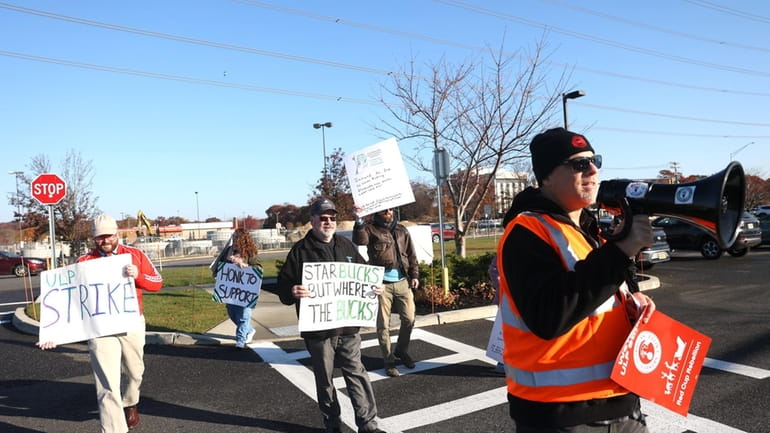 Workers rally at entrance to drive-thru at Starbucks in Farmingville on...