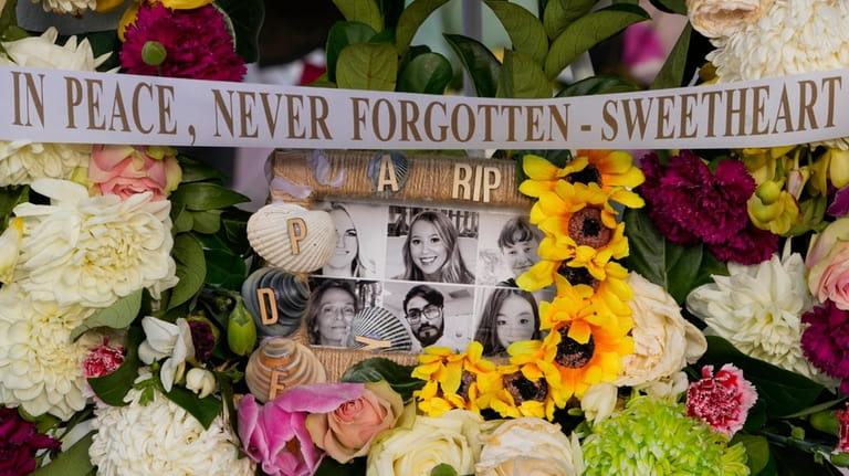 A floral tribute featuring photos of the victims in Saturday's...