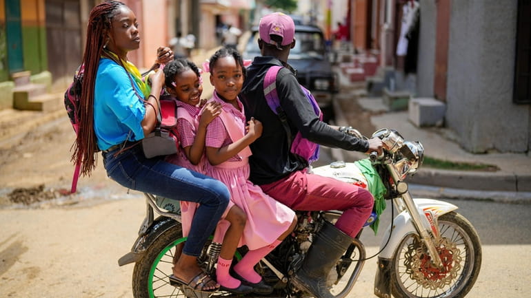 People ride on a motorcycle in Cap-Haitien, Haiti, Wednesday, April...