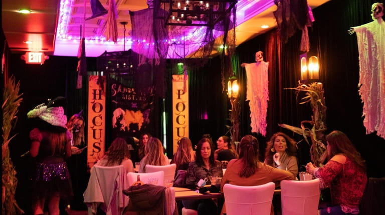 People dine at the "Hocus Pocus"-themed Halloween pop-up bar experience in Farmingdale...