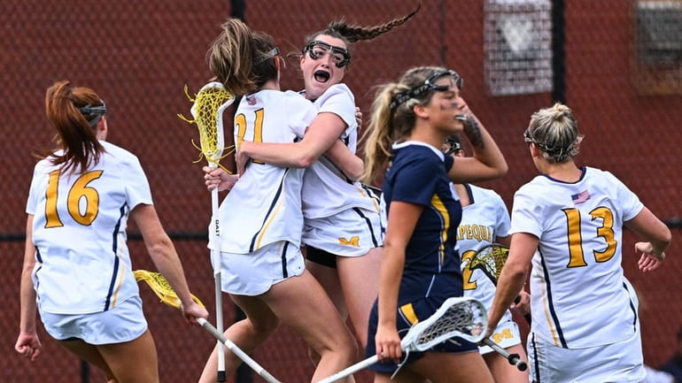 Caitlyn Dorman of Massapequa is hugged by her teammates after...