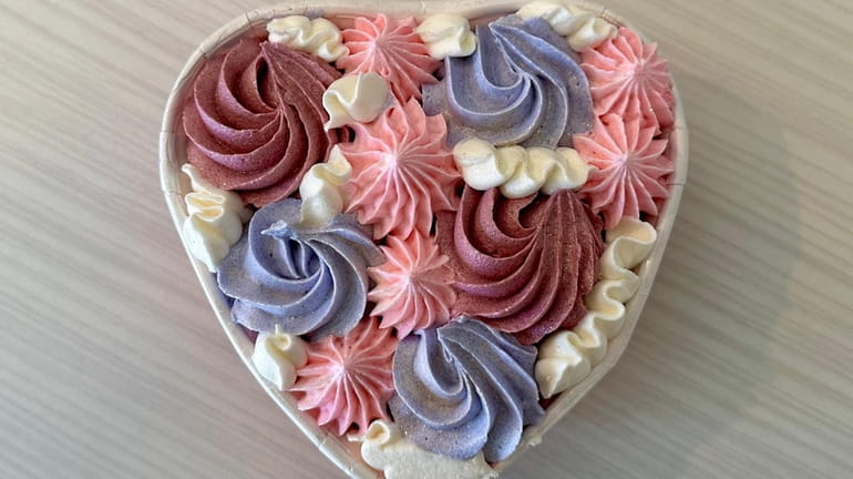 An elaborately piped heart-shaped red velvet cake for two at...