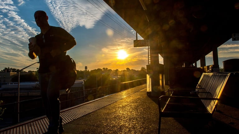 A commuter waits for a train at the LIRR station in Freeport,...