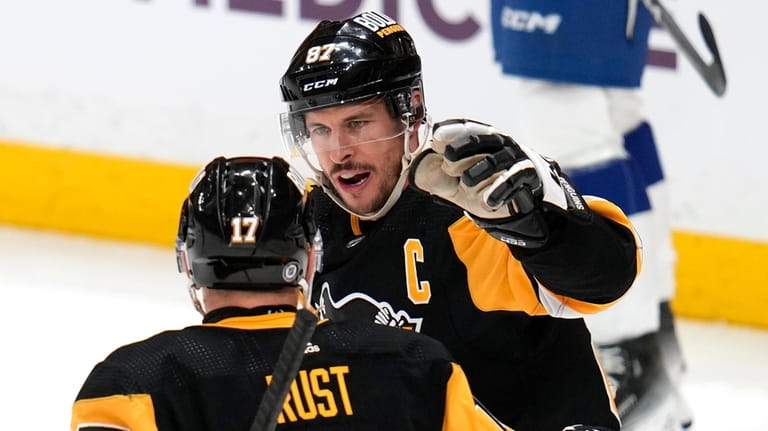 Pittsburgh Penguins' Sidney Crosby (87) celebrates with Bryan Rust after...