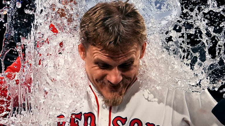 Boston Red Sox pitcher Tanner Houck is doused after he...