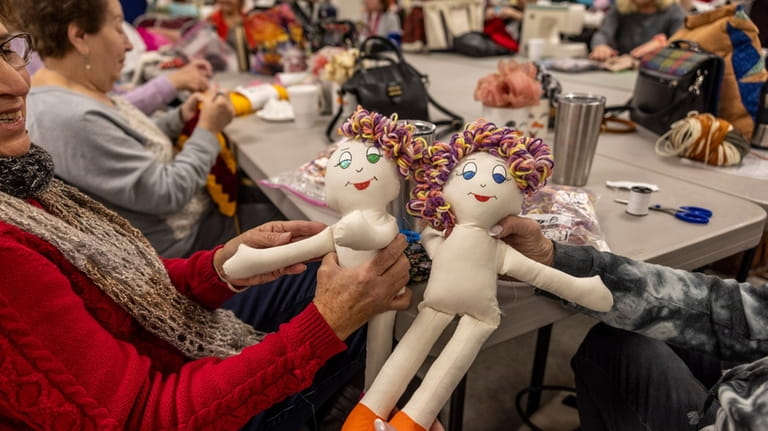Volunteers Rita Braden (left) and Beverly Buccieri compare dolls at...