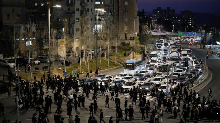 Ultra-Orthodox Jewish men and boys block a road during a...