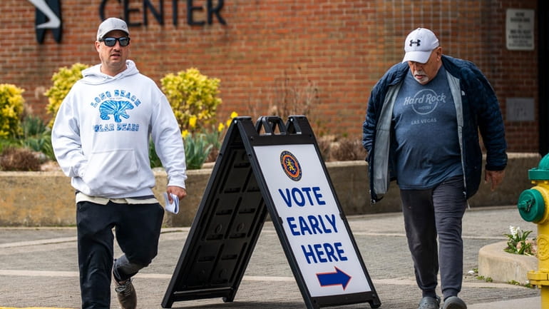 People exit a voting center during early voting in the...