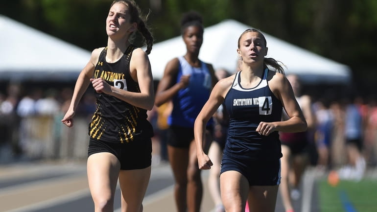 Lindsey Yakaboski of St. Anthony's, left, races to victory in...