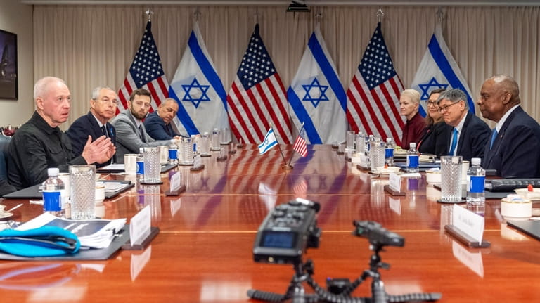 Israeli Defense Minister Yoav Gallant, at far left, speaks while...