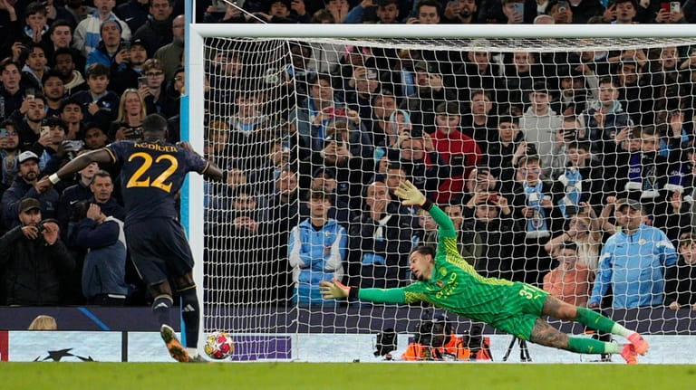 Manchester City's goalkeeper Ederson, right, fails to save the ball...