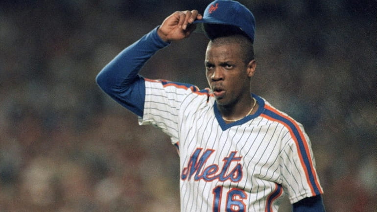 Mets pitcher Dwight Gooden tips his hat to a standing...