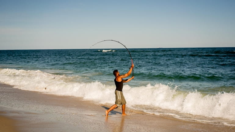 A man fishes for sharks at Tobay Beach in the...