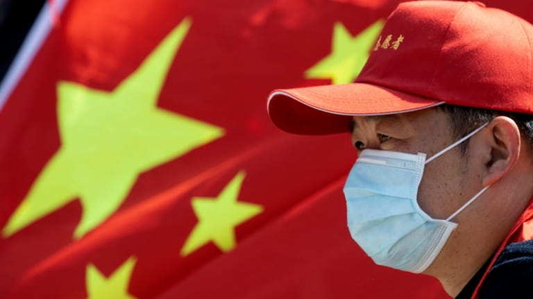 A volunteer looks out near a Chinese national flag during...