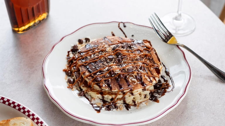 Samoa pancakes topped with toasted coconut flakes, chocolate chips, caramel...
