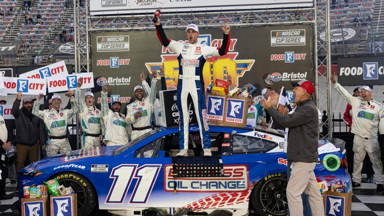 Denny Hamlin, center, celebrates after winning a NASCAR Cup Series...