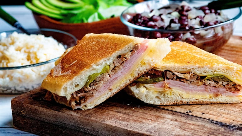 Cubanos are filled with roast pork, ham, cheese, pickles and...