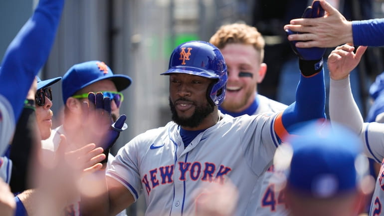 Mets' Starling Marte celebrates in the dugout after hitting a...