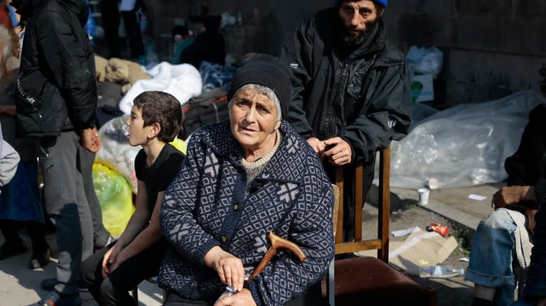 Ethnic Armenians from Nagorno-Karabakh sit next to their belongings near...