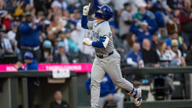 Chicago Cubs' Seiya Suzuki celebrates while running the bases on...