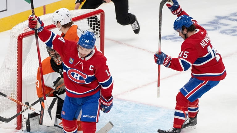 Montreal Canadiens' Nick Suzuki (14) and Alex Newhook (15) celebrate...