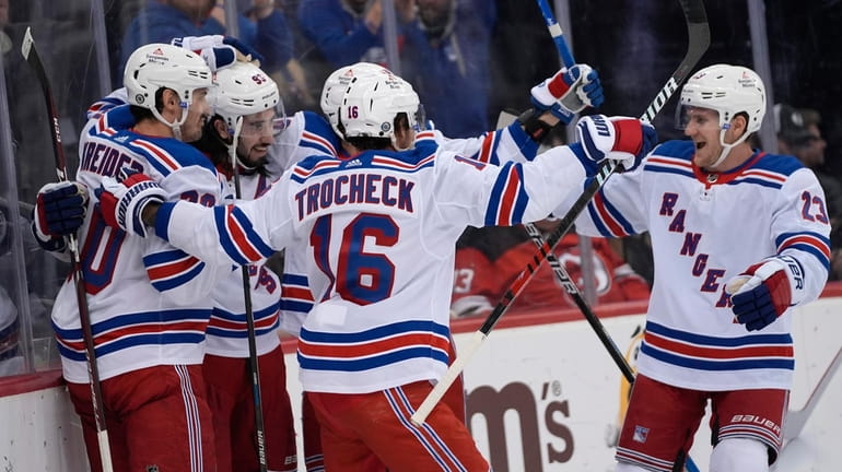 Rangers players celebrate Mika Zibanejad's goal against the Devils during...