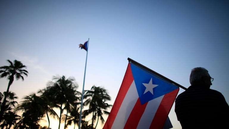 People gather in front of the Puerto Rico's Capitol on...