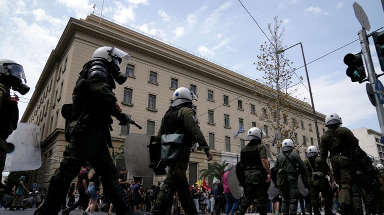 Riot police flank protesters during a rally in Athens, Greece,...
