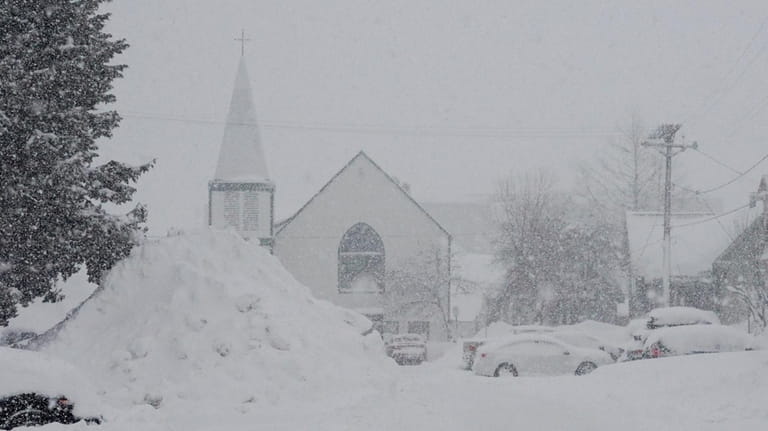 Snow piles up in front of a church during a...