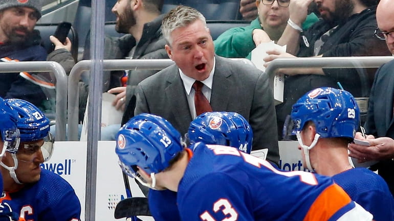 Head coach Patrick Roy of the Islanders talks with his...