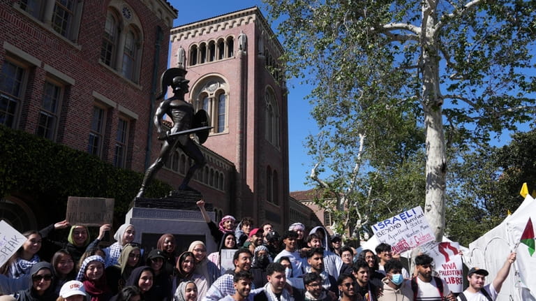 Pro-Palestinian students pose for photos in front of the Tommy...