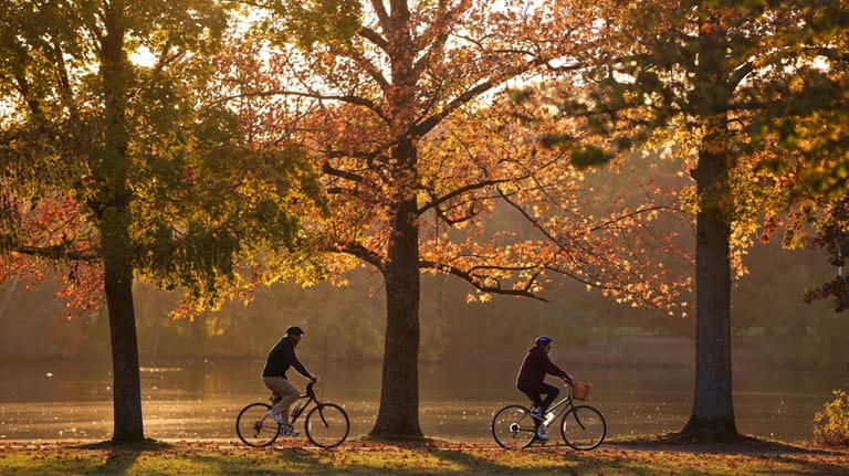 Bicyclists rides in the sunset at Belmont Lake State Park...