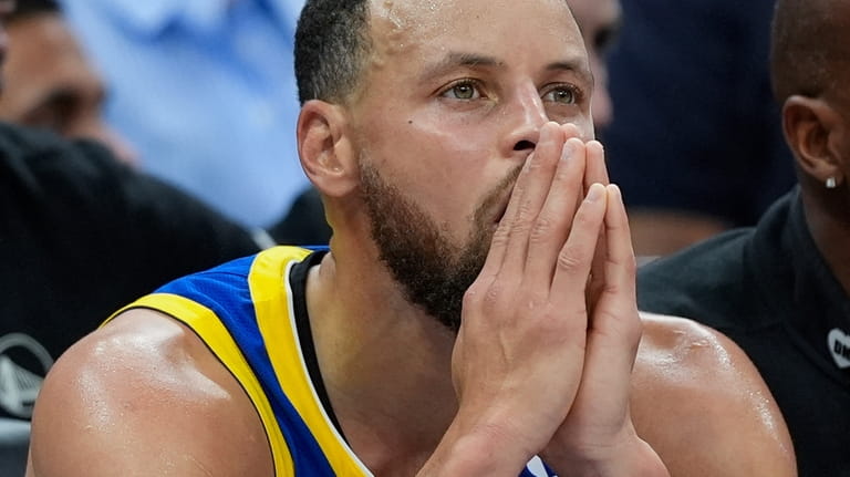 Golden State Warriors guard Stephen Curry sits on the bench...