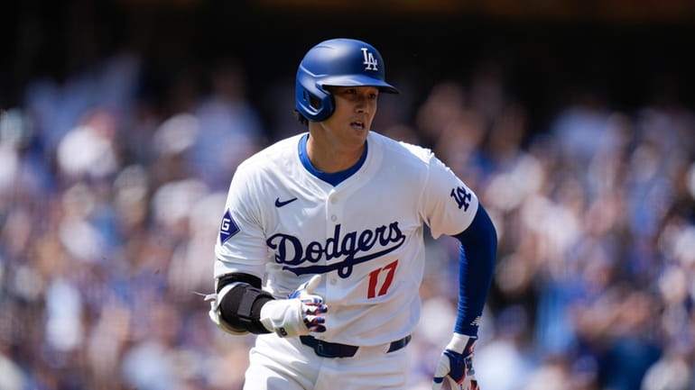 Los Angeles Dodgers' Shohei Ohtani runs to first base after...