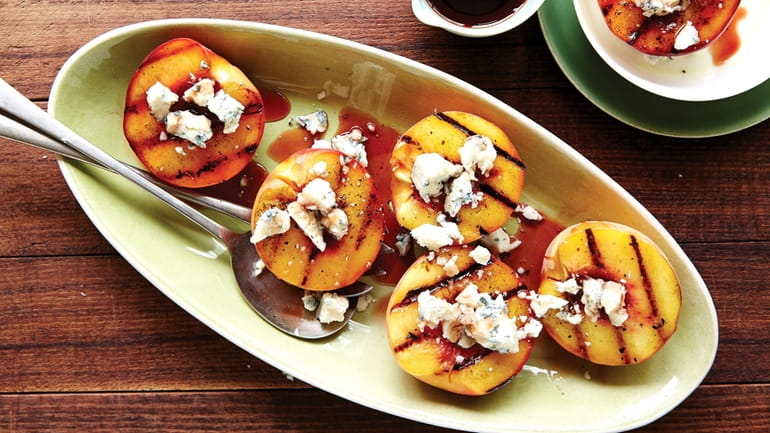Grilled peaches topped with crumbled gorgonzola and drizzled with black...