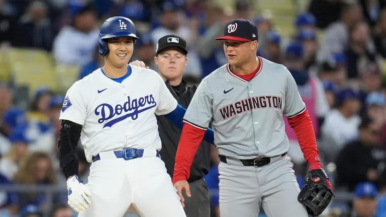 Los Angeles Dodgers' Shohei Ohtani, left, jokes with Washington Nationals...