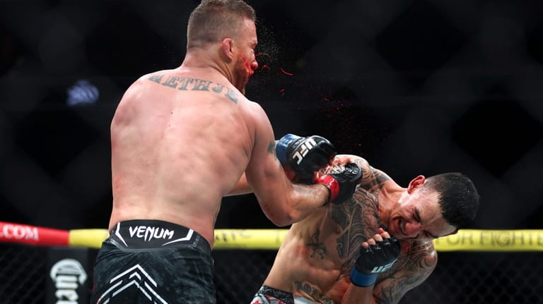 Max Holloway punches Justin Gaethje for a knockout during a...