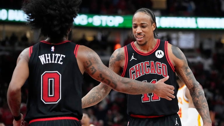 Chicago Bulls guard Coby White, left, celebrates with forward DeMar...