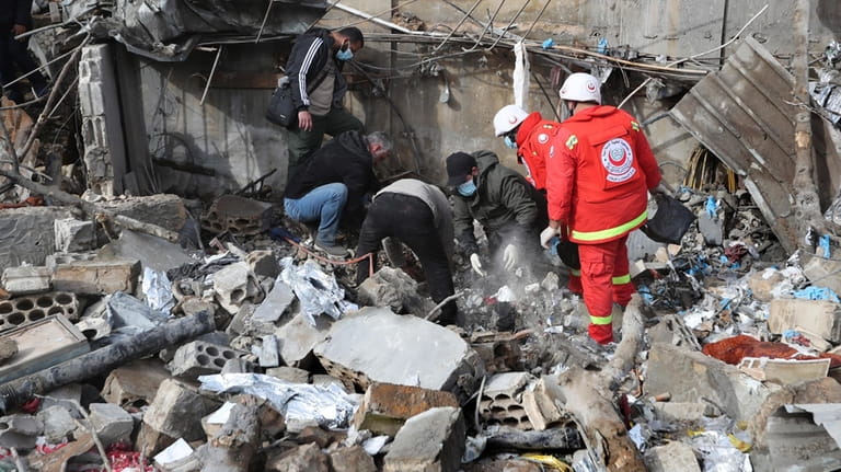 Paramedic workers search for victims in the rubble of a...