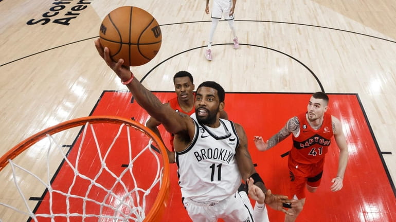 Kyrie Irving #11 of the Nets drives to the net...