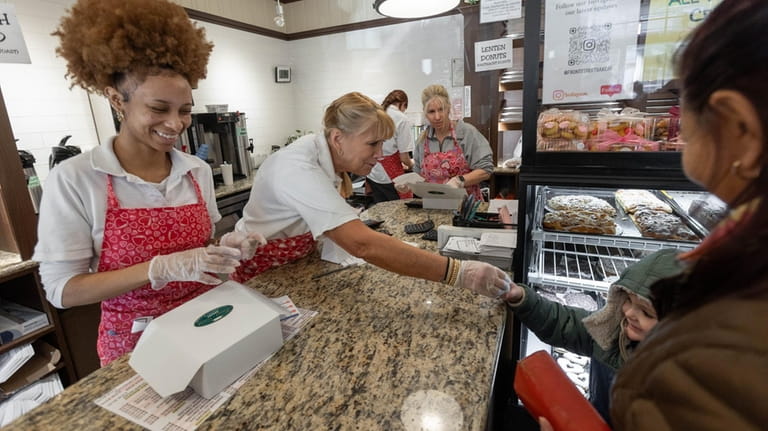 Workers at the front counter give children cookies at the...